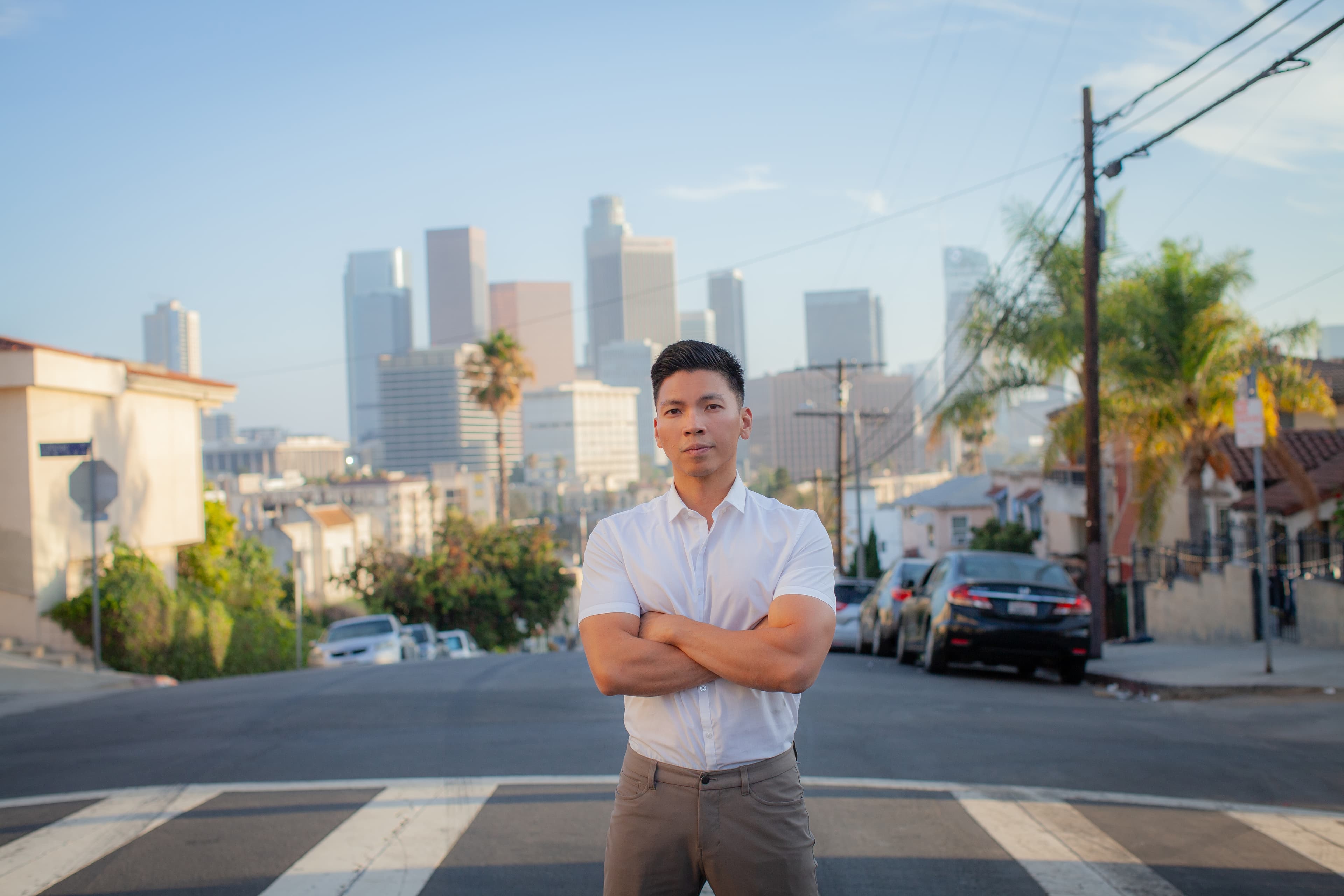 Kenneth Mejia standing in front of the Downtown Los Angeles skyline.